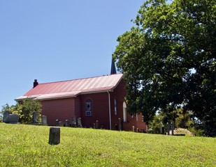 Metal Roof, Green Steeple, and Cemetery near a Red Brick Church