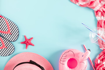 Summer beach composition. Beach pink accessories, straw hat, flip flop, starfish on blue background. Concept of summer vacations. Flat lay, top view, copy space