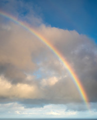 Fototapeta na wymiar Isolated rainbow in the sky with clouds on Faroe island. Big size.