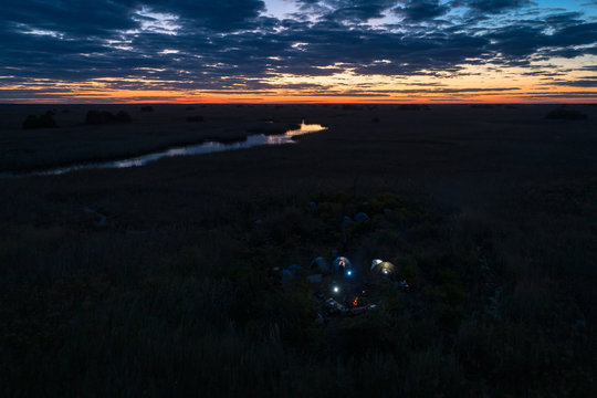 Aerial view of Cuando river with team of explorers camping in tents on the floodplains