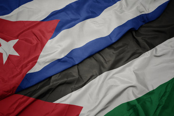 waving colorful flag of palestine and national flag of cuba.