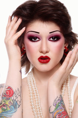 Vintage style portrait of beautiful punk woman with tattoos and fancy makeup