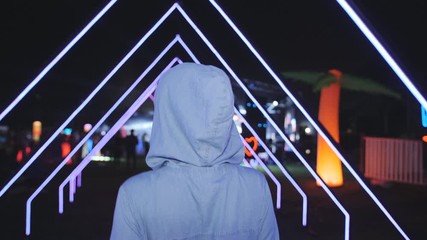 Girl goes on a slumber party under the open sky. Festival dance party outdoors. Neon lights and laser beams.
