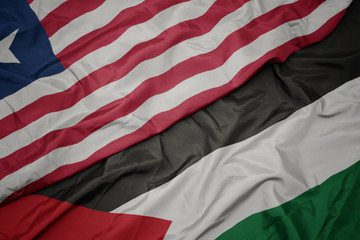 waving colorful flag of palestine and national flag of liberia.
