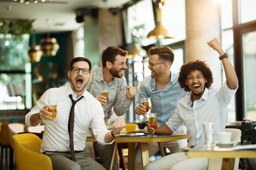 Friends are happy while watching game at te ub and drinking beer.