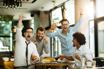 Friends are happy while watching game at te ub and drinking beer.