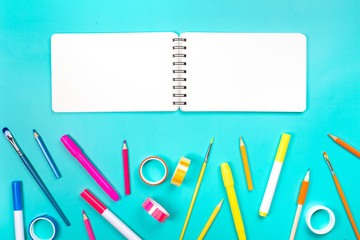 School items as a frame on blue background. Trendy colors, flat lay style. Back to school concept.