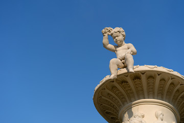 Obraz premium A boy statue in a public garden looks down.