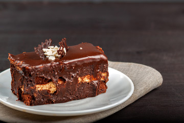 Dish with a slice of chocolate cake stands on a wooden table