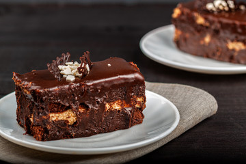 Dish with a slice of chocolate cake stands on a wooden table