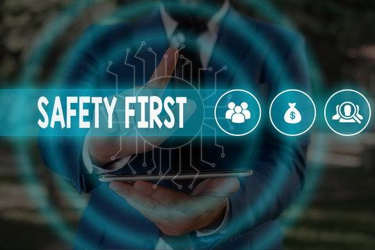 Handwriting text Safety First. Conceptual photo used to say that the most important thing is to be safe Male human wear formal work suit presenting presentation using smart device