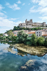 Fototapeta na wymiar The old town of Béziers reflected in the waters of Orb river in a summer day. Béziers, France.
