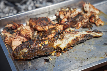 Grilled fish lies on a metal dish