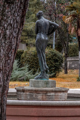 Back view of black woman statue carrying water in a bottle.. Garden, City of Rijeka , Croatia.