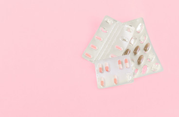 Medicine pills, capsules on pink background.Concept of medicine.Medicines for the treatment of diseases, viruses, autumn cold season, beriberi, hypothermia, vaccination