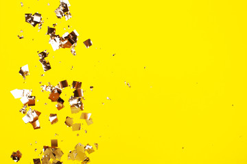 Falling silver confetti on yellow backdrop. Holiday concept.