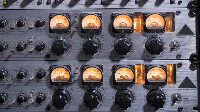 Closeup of adjustable handles and displays on compressor panel in professional record studio. Audio compressor reducing or compressing audio signal's dynamic range during sound recording in studio