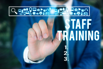 Word writing text Staff Training. Business photo showcasing program that helps employees learn specific knowledge Male human wear formal work suit presenting presentation using smart device