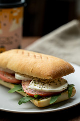 Grilled caprese ciabatta with tomatoes, pasta sauce and mozzarella, served with a cup of coffee