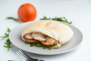 Greek soft pita, stuffed with veggies, arugula and chicken breast as a healthy snack in cafe