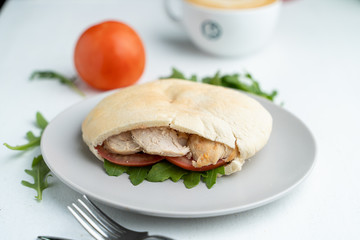 Greek soft pita, stuffed with veggies, arugula and chicken breast as a healthy snack in cafe