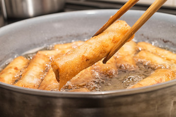 Vietnamese egg rolls, cha gio, deep fried in boiling oil pan