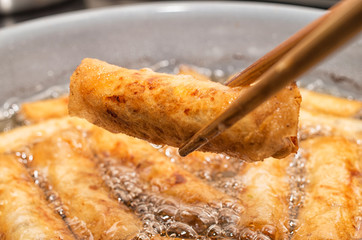 Vietnamese egg rolls, cha gio, deep fried in boiling oil pan
