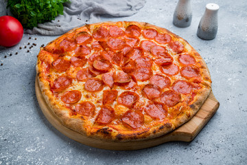 Pepperoni pizza on board on beautiful grey table