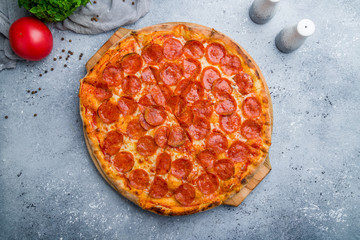 Pepperoni pizza on board on beautiful grey table