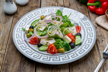 Greek salad with feta on old wooden table