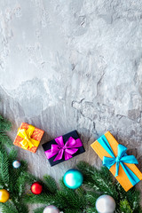 Presents for christmas in boxes and spruce frame on gray stone background top veiw copyspace