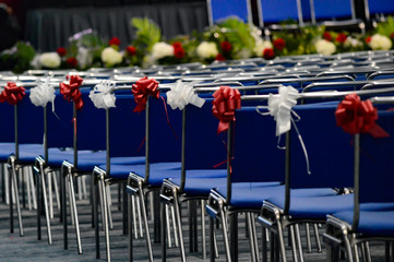 Rows of seats with red and white ribbons waiting for graduating students