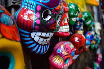 Fototapeta na wymiar Many hand-painted, brightly-colored Dia de los Muertos skull souvenirs