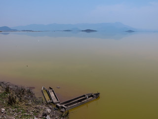 View of the big lake with reflected hill and old boats