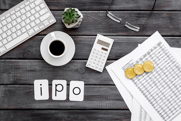 Obraz na płótnie Canvas IPO with coins, calculation table, keyboard, coffee on office desk gray wooden background top view