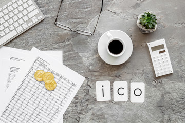 Initial coin offering ICO with coins, calculation table, office tools, coffee on gray textured background top view