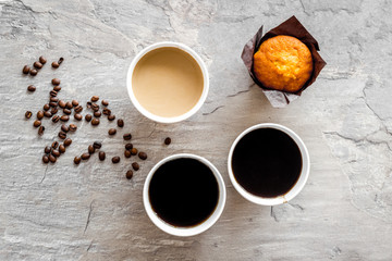 Breakfast with muffin and coffee to-go on gray background top view