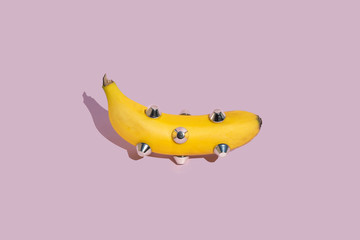 banana dressed with tacks isolated on pink background