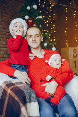 Cute family have fun in decorating room. Handsome father with little son. Family in a red sweaters