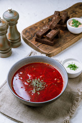 Borscht with sour cream on white concrete table