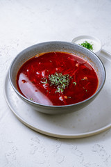 Borscht with sour cream on white concrete table