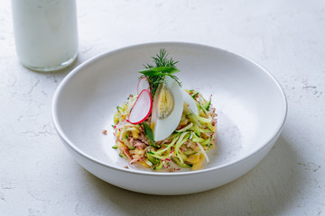 Okroshka on kefir on white concrete table