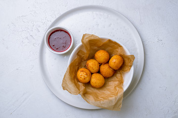 fried Cheese balls with berry sause on white concrete table