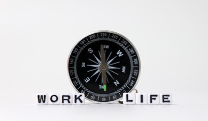A compass between WORK word and LIFE word on white cubes.