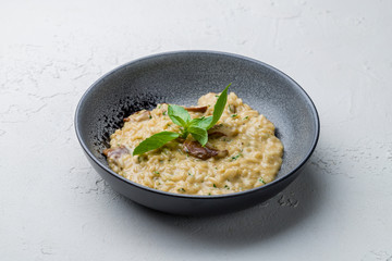 risotto with porcini mushrooms on white concrete table