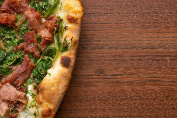 Pepperoni  and escarole pizza on a wooden background. Top view. Flat view.