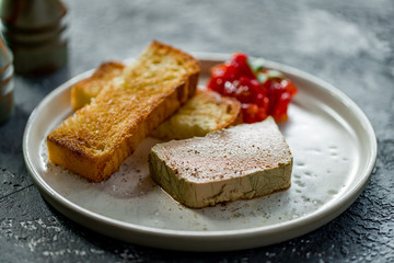 Fototapeta na wymiar The chicken liver pate with bread and jam on dark grey concrete table