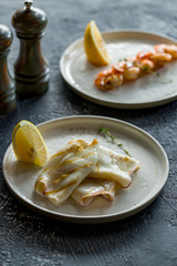 Roasted squid on board on dark grey concrete table