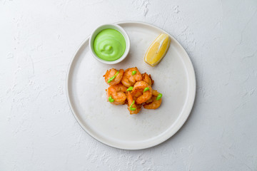 Fried shrimp with wasabi sause on white concrete table