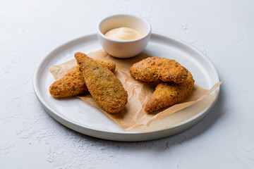 Fried chicken nuggets with cheese sause on white concrete table